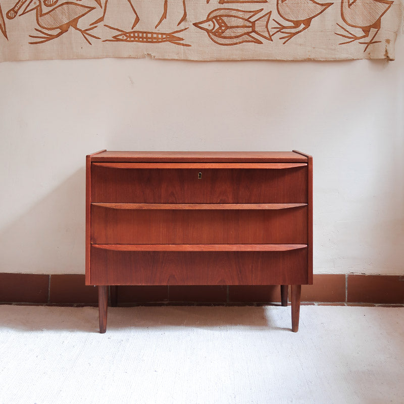 Commode scandinave en teck années 60 à trois tiroirs avec façade galbée et pieds compas.