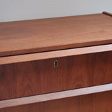Commode scandinave en teck années 60 à trois tiroirs avec façade galbée et pieds compas.