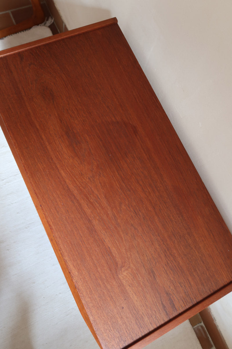 Commode scandinave en teck années 60 à trois tiroirs avec façade galbée et pieds compas.
