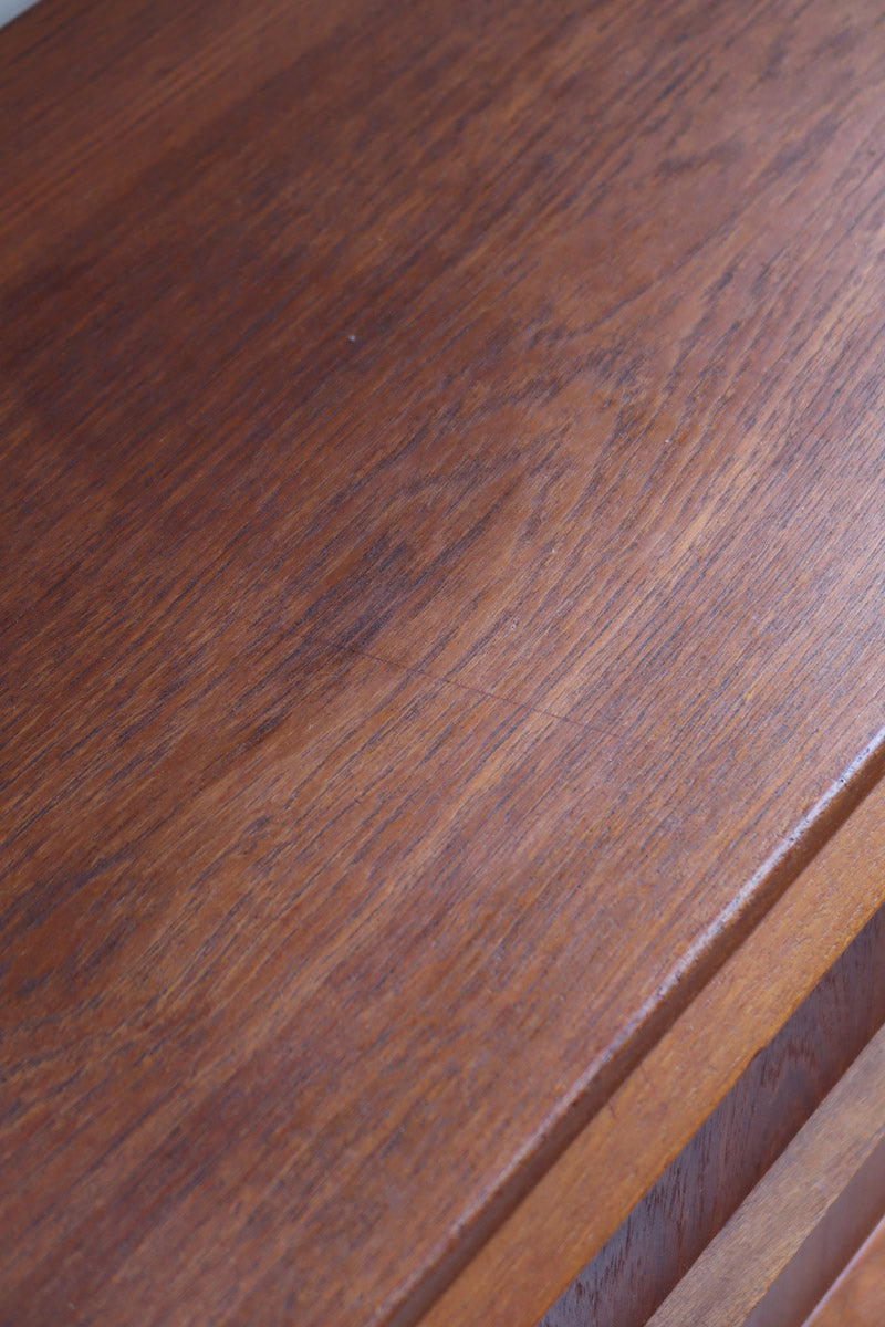 Commode scandinave en teck années 60 à trois tiroirs avec façade galbée et pieds compas.