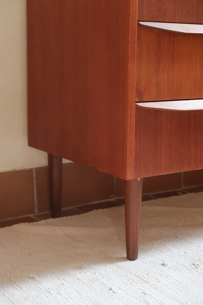 Commode scandinave en teck années 60 à trois tiroirs avec façade galbée et pieds compas.