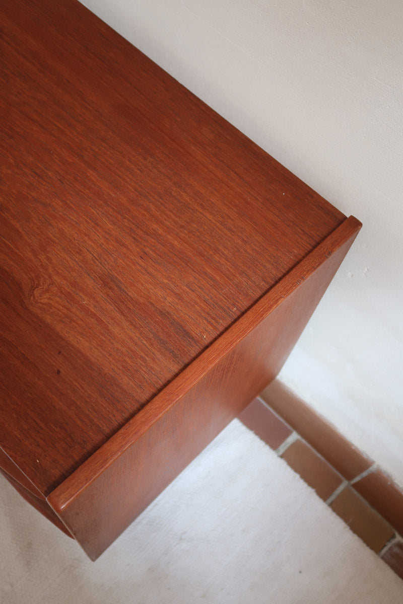Commode scandinave en teck années 60 à trois tiroirs avec façade galbée et pieds compas.