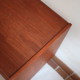 Commode scandinave en teck années 60 à trois tiroirs avec façade galbée et pieds compas.