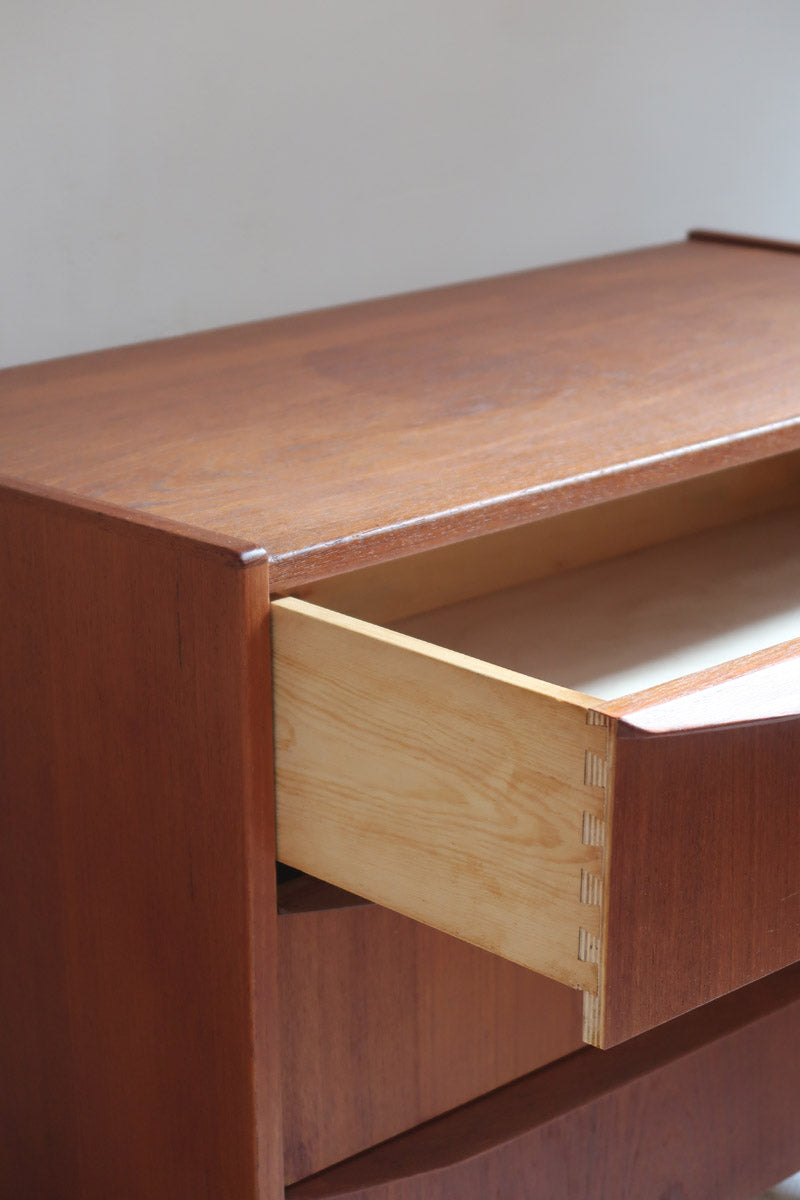 Commode scandinave en teck années 60 à trois tiroirs avec façade galbée et pieds compas.