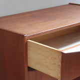 Commode scandinave en teck années 60 à trois tiroirs avec façade galbée et pieds compas.