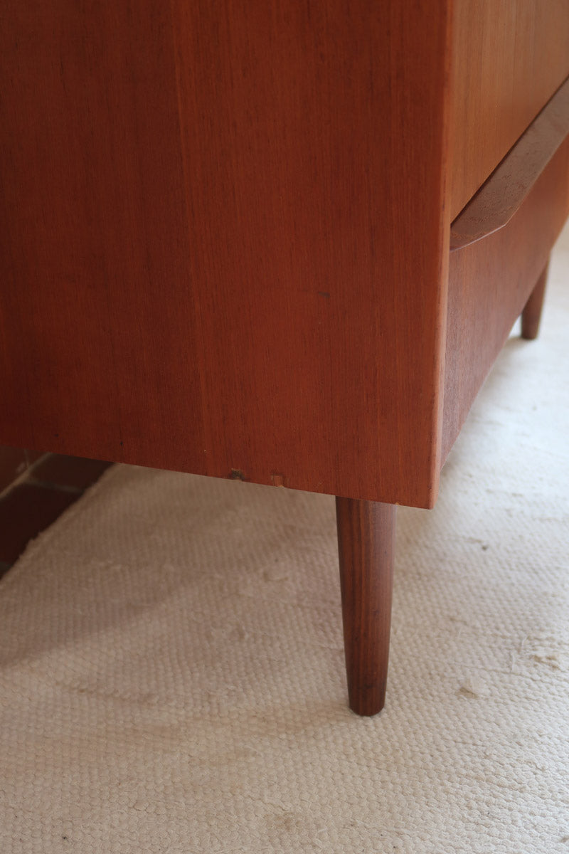 Commode scandinave en teck années 60 à trois tiroirs avec façade galbée et pieds compas.