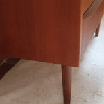 Commode scandinave en teck années 60 à trois tiroirs avec façade galbée et pieds compas.