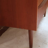 Commode scandinave en teck années 60 à trois tiroirs avec façade galbée et pieds compas.
