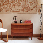 Commode scandinave en teck années 60 à trois tiroirs avec façade galbée et pieds compas.