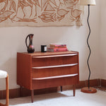 Commode scandinave en teck années 60 à trois tiroirs avec façade galbée et pieds compas.