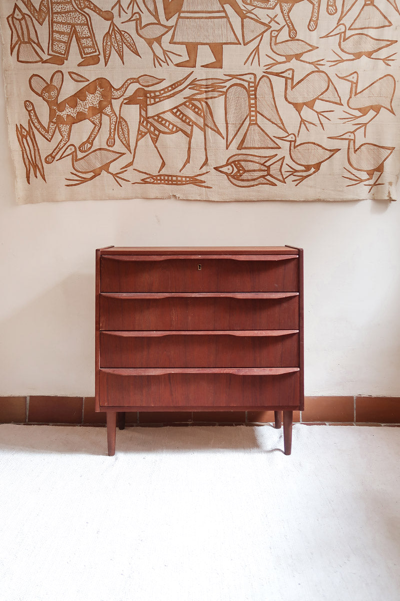 Commode scandinave en teck années 60 à quatre tiroirs et pieds compas, teinte chaude, design mid century.