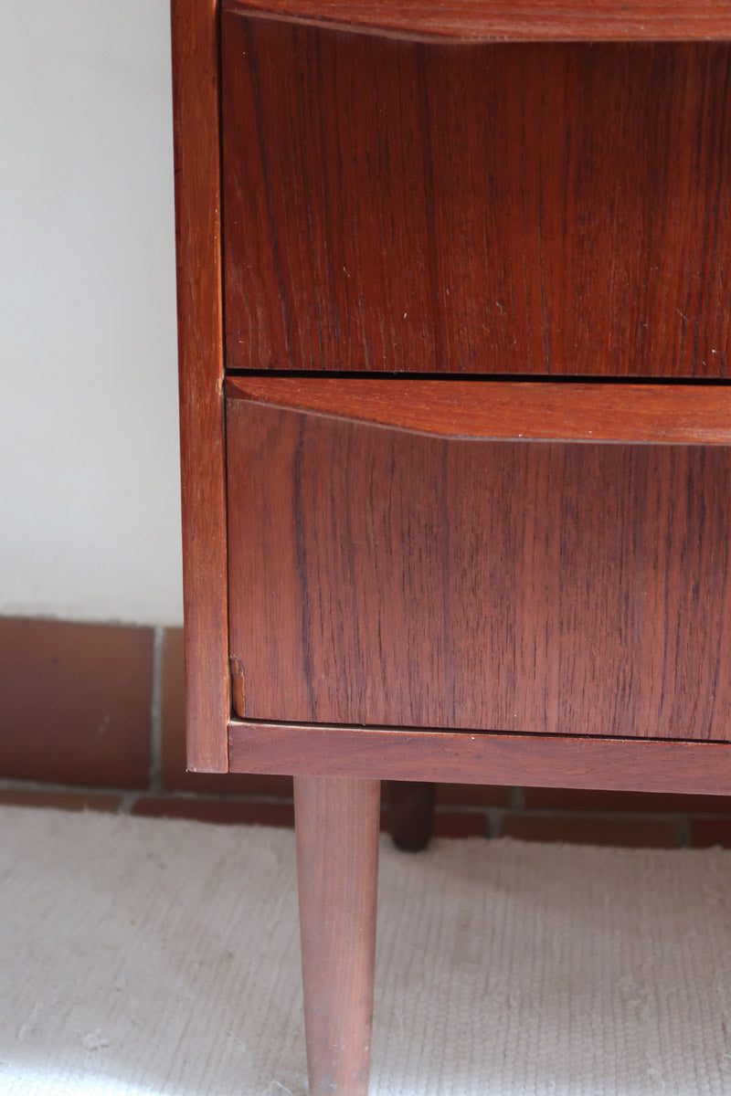 Commode scandinave en teck années 60 à quatre tiroirs et pieds compas, teinte chaude, design mid century.
