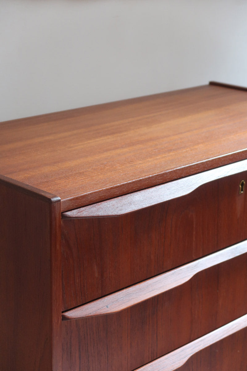Commode scandinave en teck années 60 à quatre tiroirs et pieds compas, teinte chaude, design mid century.