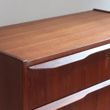 Commode scandinave en teck années 60 à quatre tiroirs et pieds compas, teinte chaude, design mid century.