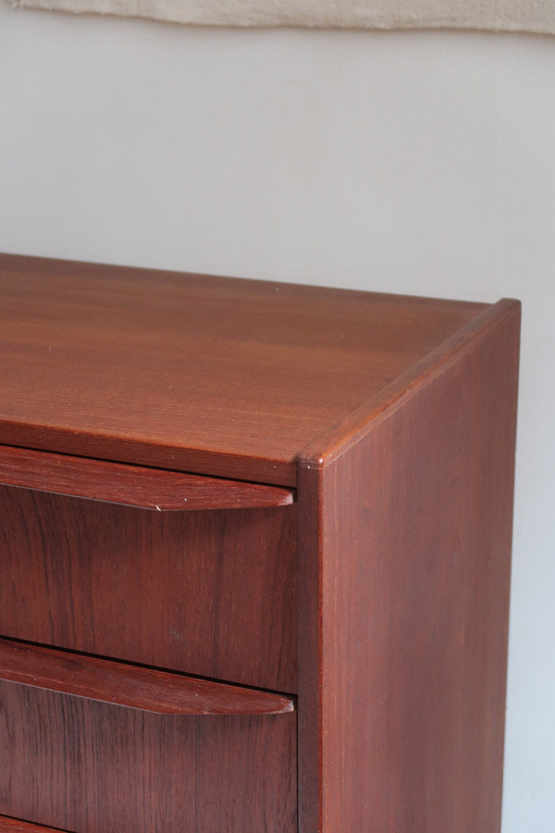 Commode scandinave en teck années 60 à quatre tiroirs et pieds compas, teinte chaude, design mid century.