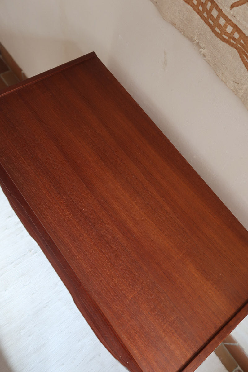 Commode scandinave en teck années 60 à quatre tiroirs et pieds compas, teinte chaude, design mid century.