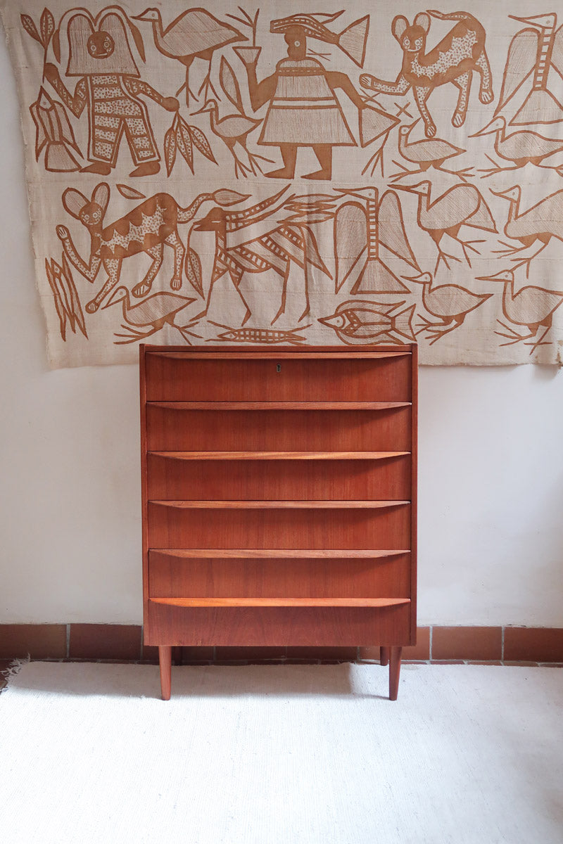 Commode scandinave en teck années 60 à cinq tiroirs, poignées sculptées intégrées et pieds compas.