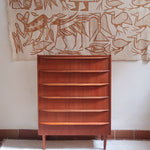 Commode scandinave en teck années 60 à cinq tiroirs, poignées sculptées intégrées et pieds compas.