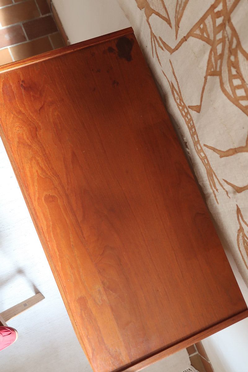 Commode scandinave en teck années 60 à cinq tiroirs, poignées sculptées intégrées et pieds compas.