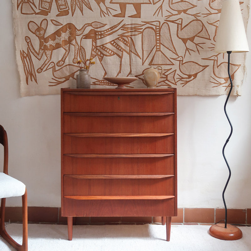 Commode scandinave en teck années 60 à cinq tiroirs, poignées sculptées intégrées et pieds compas.