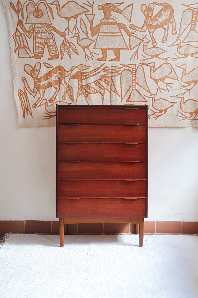 Commode haute scandinave en teck années 60 à six tiroirs avec poignées intégrées et piètement fuselé.