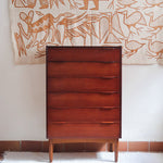 Commode haute scandinave en teck années 60 à six tiroirs avec poignées intégrées et piètement fuselé.