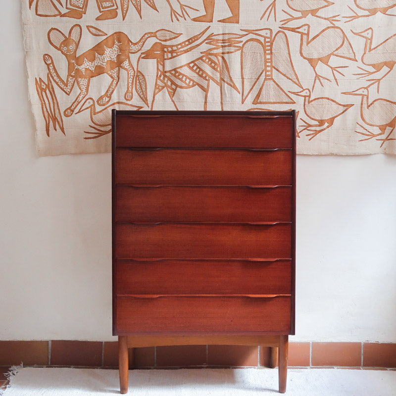 Commode haute scandinave en teck années 60 à six tiroirs avec poignées intégrées et piètement fuselé.