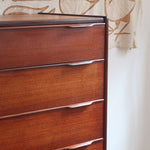 Commode haute scandinave en teck années 60 à six tiroirs avec poignées intégrées et piètement fuselé.