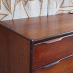 Commode haute scandinave en teck années 60 à six tiroirs avec poignées intégrées et piètement fuselé.