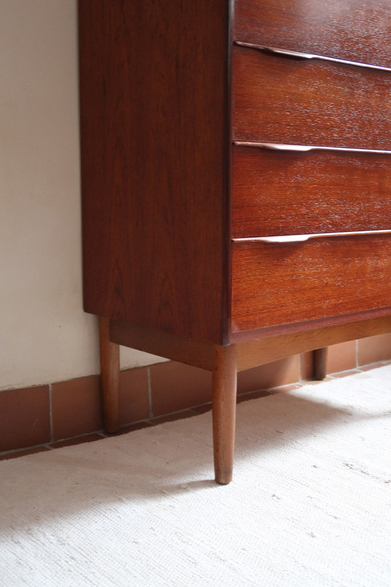 Commode haute scandinave en teck années 60 à six tiroirs avec poignées intégrées et piètement fuselé.