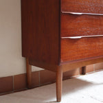 Commode haute scandinave en teck années 60 à six tiroirs avec poignées intégrées et piètement fuselé.