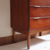 Commode haute scandinave en teck années 60 à six tiroirs avec poignées intégrées et piètement fuselé.