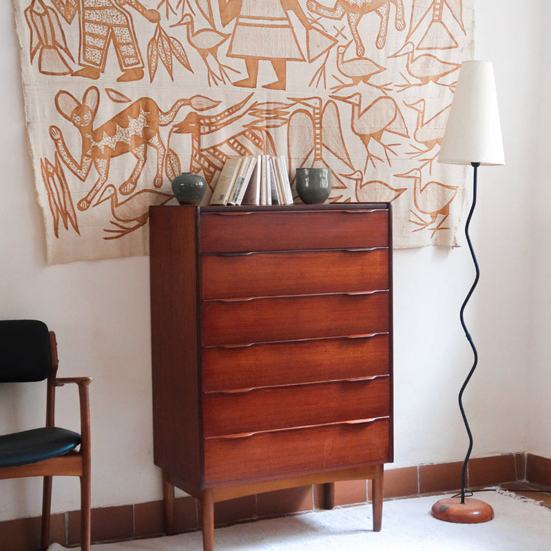 Commode haute scandinave en teck années 60 à six tiroirs avec poignées intégrées et piètement fuselé.