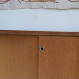 Meuble bas années 70 en bois avec piètement et montants en métal chromé, portes coulissantes et étagère intérieure.