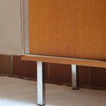 Meuble bas années 70 en bois avec piètement et montants en métal chromé, portes coulissantes et étagère intérieure.