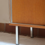 Meuble bas années 70 en bois avec piètement et montants en métal chromé, portes coulissantes et étagère intérieure.