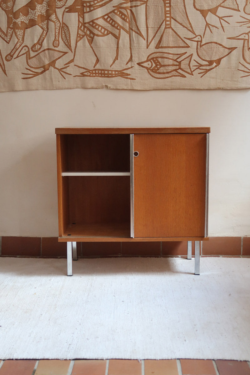 Meuble bas années 70 en bois avec piètement et montants en métal chromé, portes coulissantes et étagère intérieure.