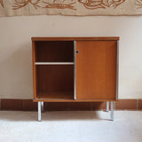 Meuble bas années 70 en bois avec piètement et montants en métal chromé, portes coulissantes et étagère intérieure.