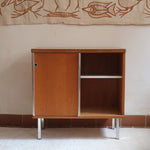 Meuble bas années 70 en bois avec piètement et montants en métal chromé, portes coulissantes et étagère intérieure.