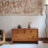 Commode basse en pin massif années 70 à trois tiroirs avec assemblages à queues d’aronde visibles et poignées rondes en bois.
