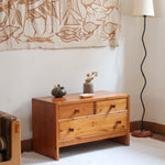 Commode basse en pin massif années 70 à trois tiroirs avec assemblages à queues d’aronde visibles et poignées rondes en bois.