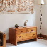 Commode basse en pin massif années 70 à trois tiroirs avec assemblages à queues d’aronde visibles et poignées rondes en bois.