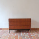Commode vintage 3 tiroirs en teck années 60, façades pleines à prise de main creusée, piétement fin en métal laqué noir, style scandinave