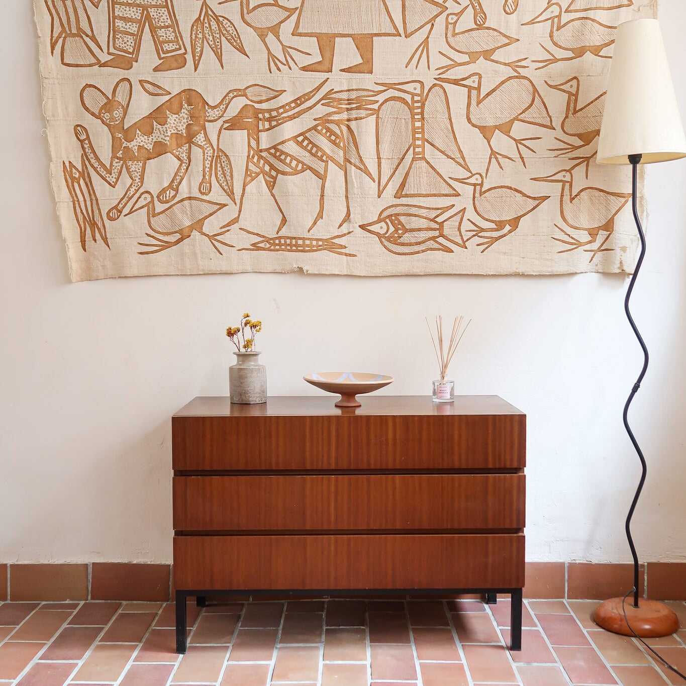 Commode vintage 3 tiroirs en teck années 60, façades pleines à prise de main creusée, piétement fin en métal laqué noir, style scandinave