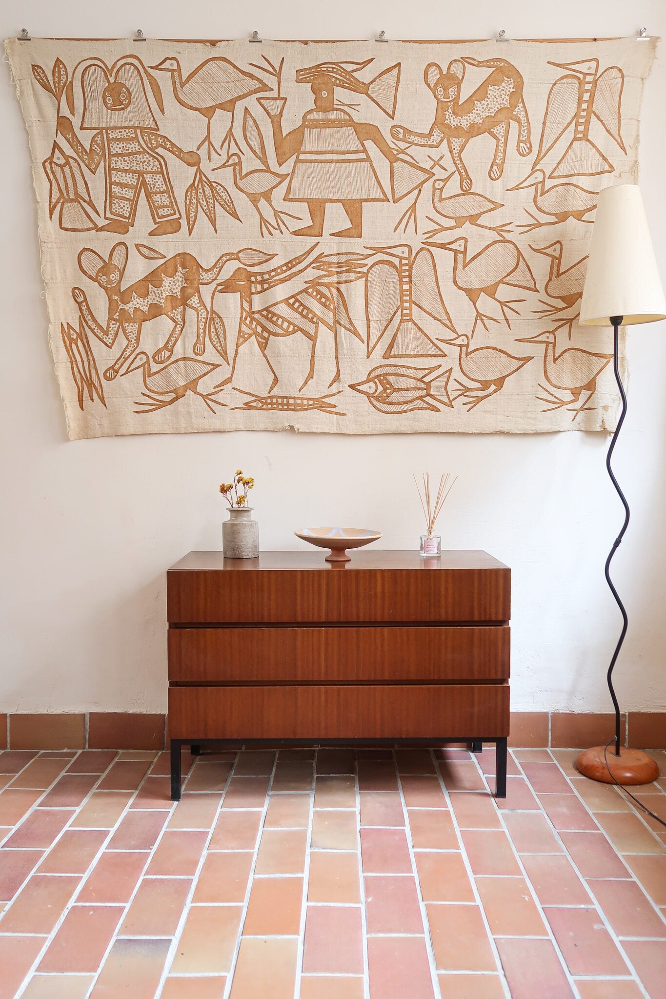 Commode vintage 3 tiroirs en teck années 60, façades pleines à prise de main creusée, piétement fin en métal laqué noir, style scandinave