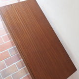 Commode vintage 3 tiroirs en teck années 60, façades pleines à prise de main creusée, piétement fin en métal laqué noir, style scandinave
