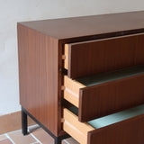 Commode vintage 3 tiroirs en teck années 60, façades pleines à prise de main creusée, piétement fin en métal laqué noir, style scandinave