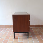 Commode vintage 3 tiroirs en teck années 60, façades pleines à prise de main creusée, piétement fin en métal laqué noir, style scandinave