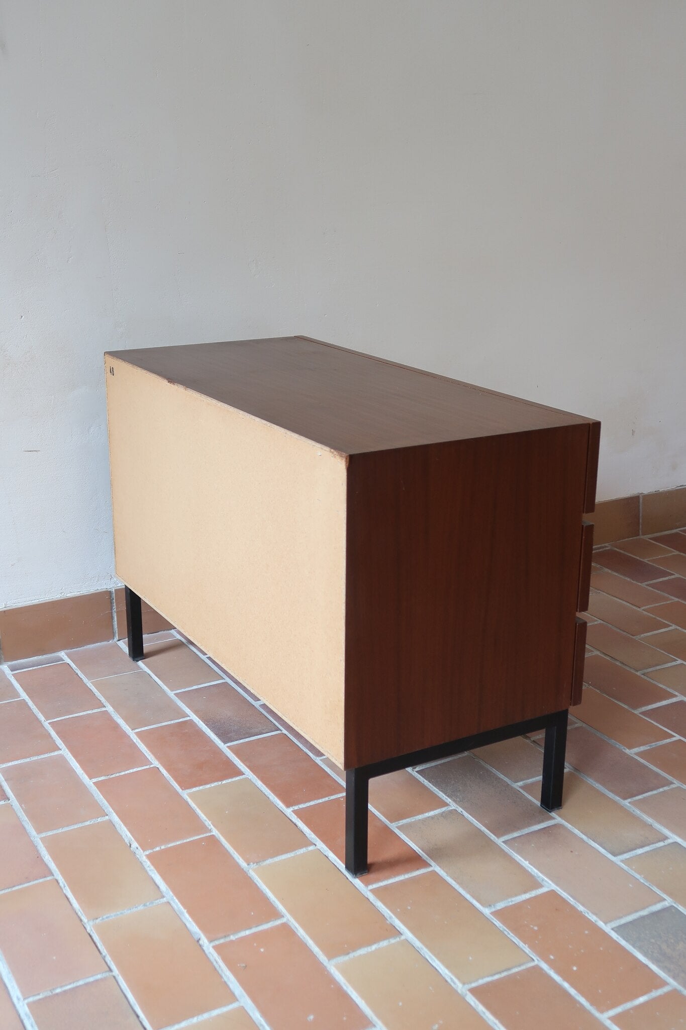 Commode vintage 3 tiroirs en teck années 60, façades pleines à prise de main creusée, piétement fin en métal laqué noir, style scandinave