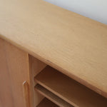 Enfilade scandinave vintage en chêne clair, porte coulissante à poignée gorge, étagères ouvertes à hauteur modulable, petits pieds ronds, faible profondeur 33 cm